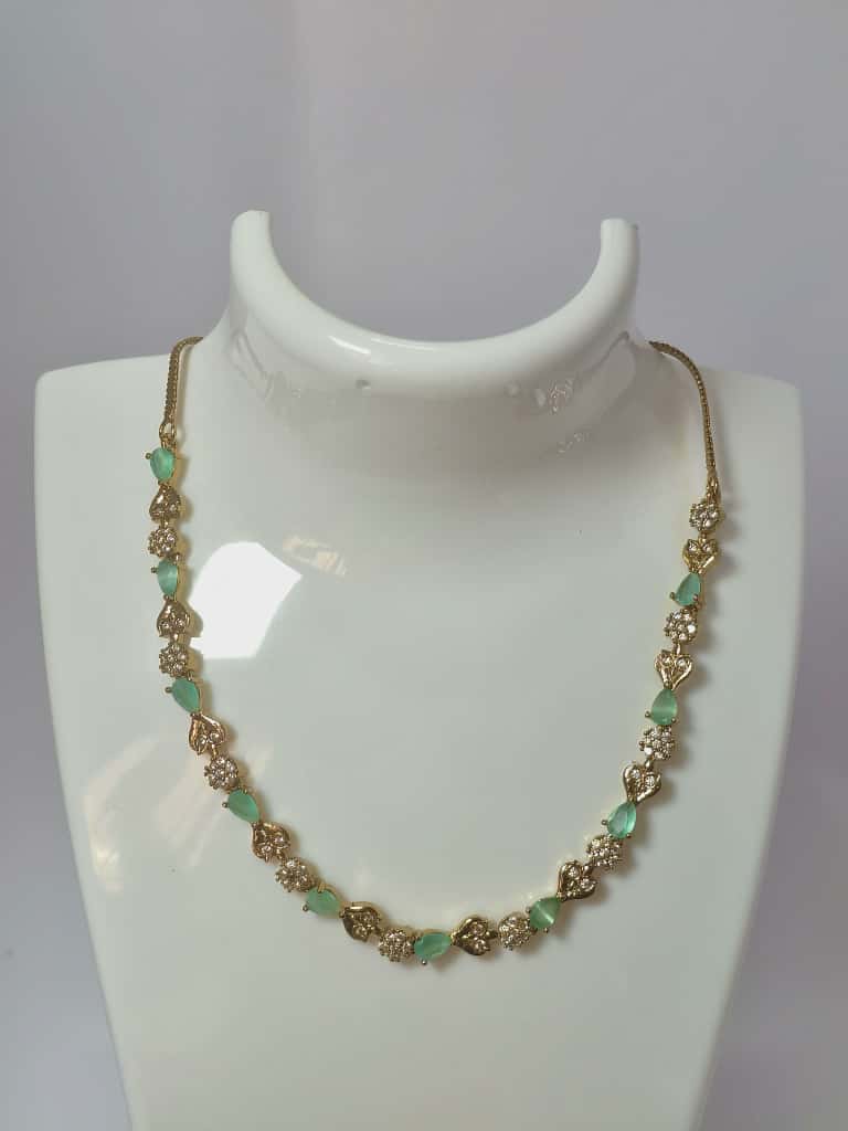 Designer necklace crystal clusters and teardrop-shaped stones in gold-tone base.